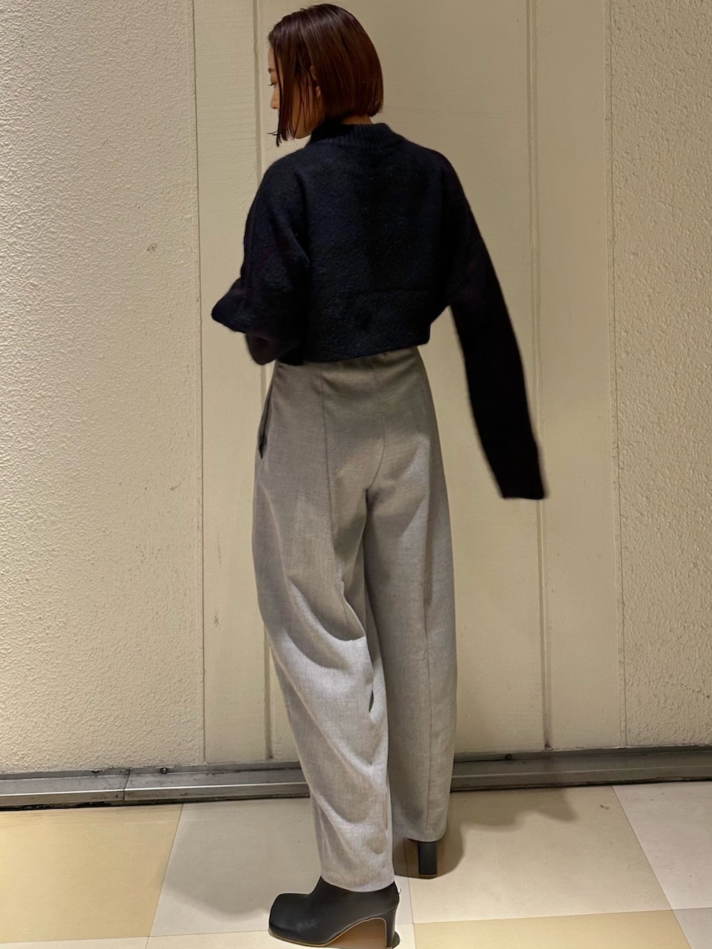 ブラック系のニット/セーター、グレー系のその他パンツ、ブラック系のブーツを着用したレディースの冬コーディネートの2枚目の写真