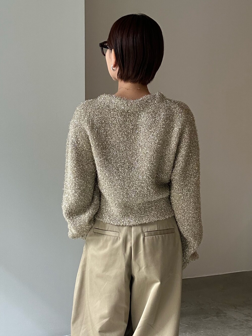 ゴールド系のカーディガン/ボレロ、ベージュ系のその他パンツ、ブラック系のサンダルを着用したレディースの冬コーディネートの8枚目の写真