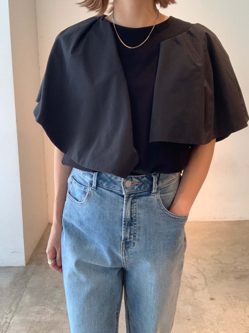 ブラック系のTシャツ/カットソー、ブルー系のデニムパンツ、ブラック系のサンダルを着用したレディースの春コーディネートの7枚目の写真
