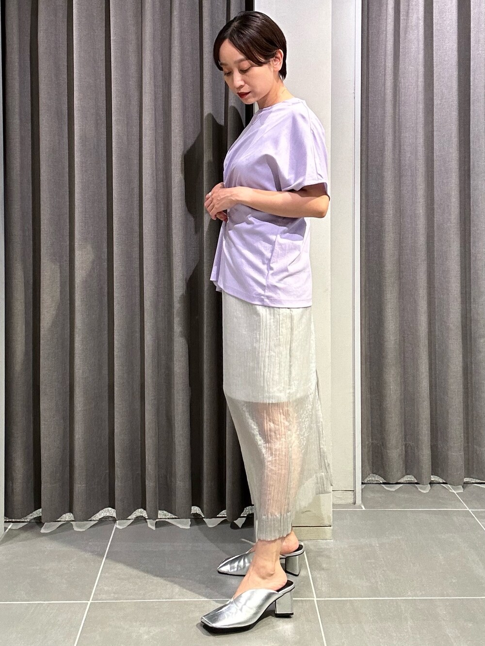 パープル系のTシャツ/カットソー、グレー系のスカート、シルバー系のパンプスを着用したレディースの夏コーディネートの4枚目の写真
