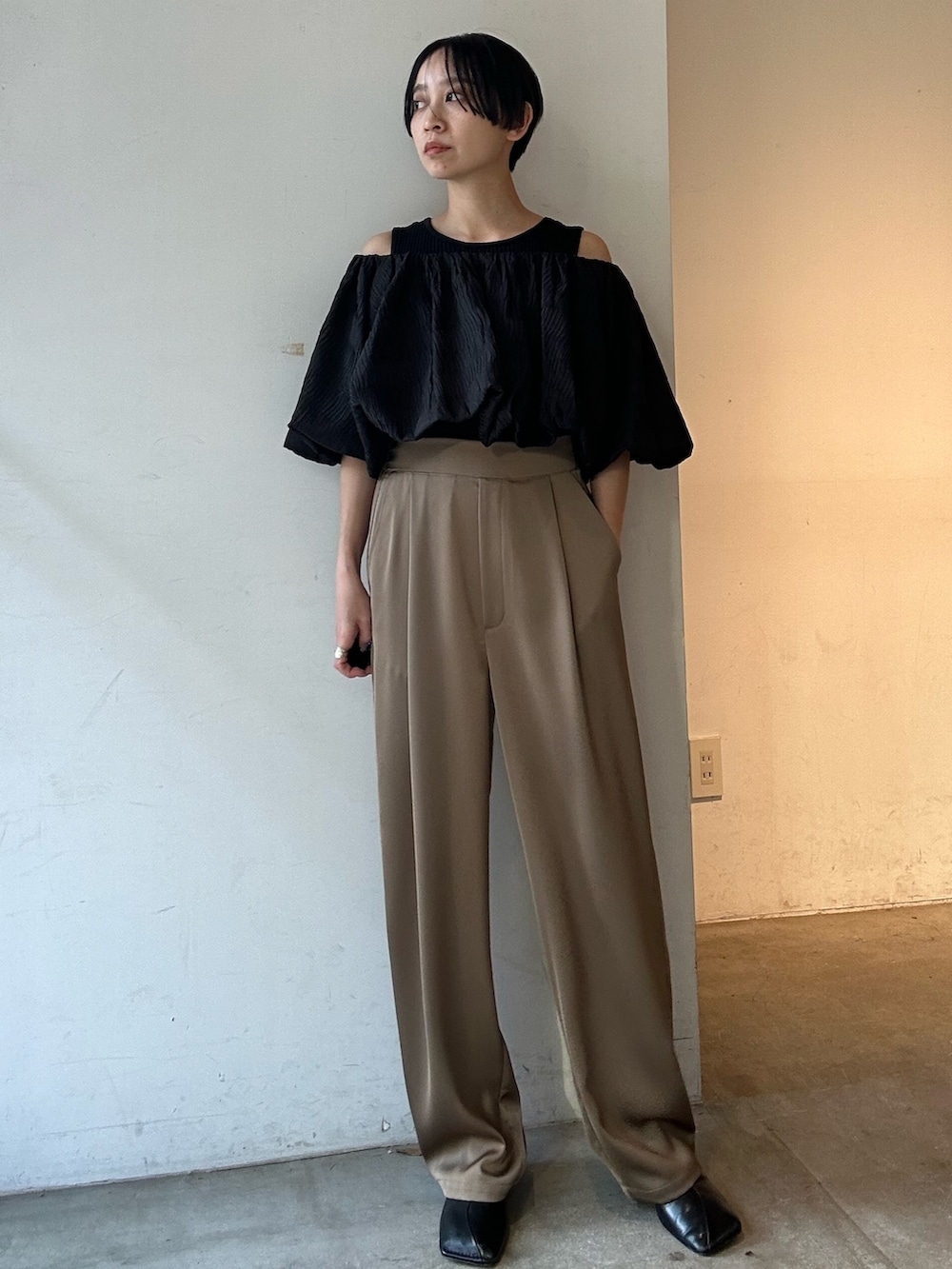 ブラック系のシャツ/ブラウス、ベージュ系のその他パンツ、ブラック系のパンプスを着用したレディースの春コーディネートの2枚目の写真