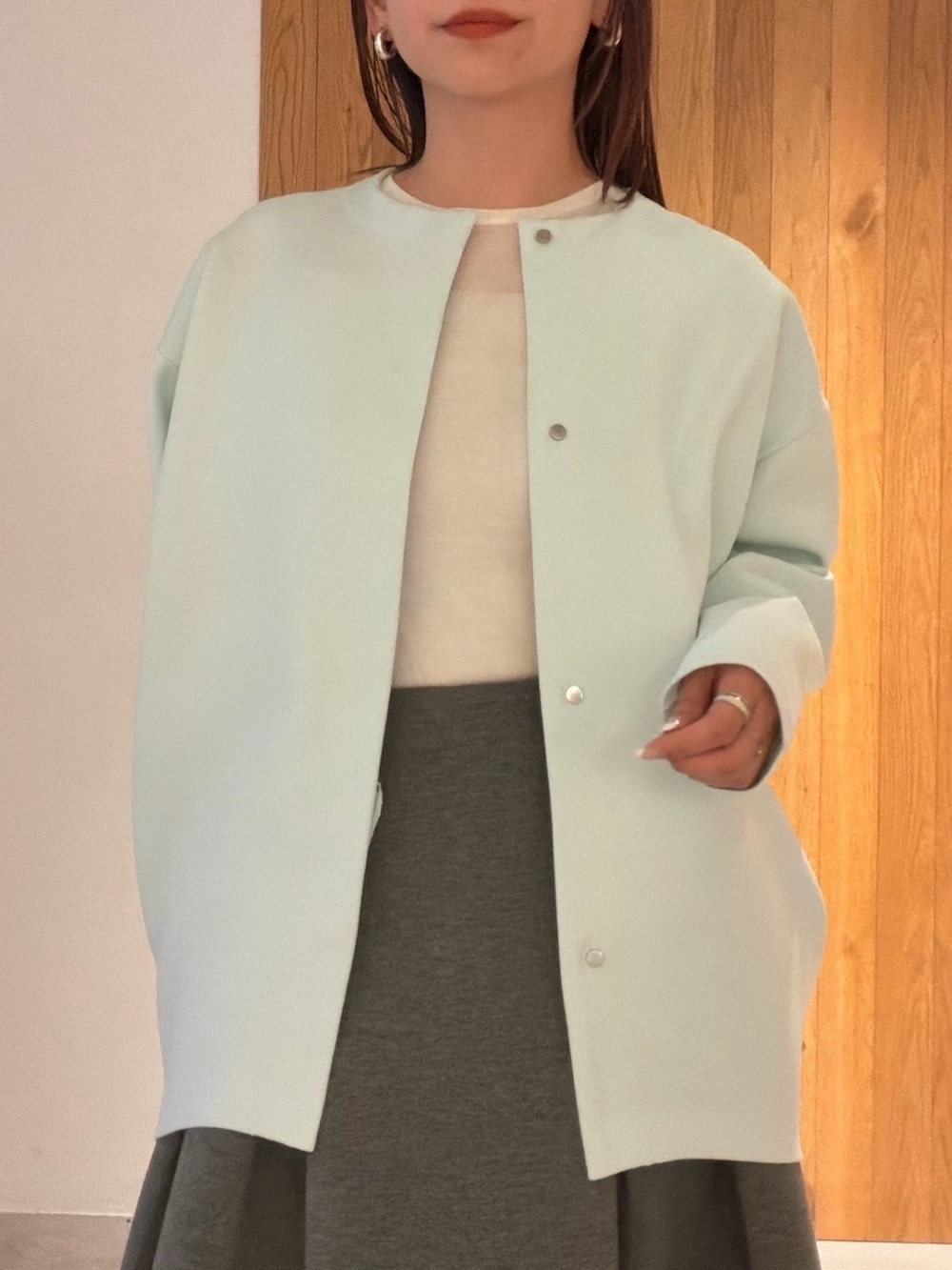 グレー系のスカート、ホワイト系のスニーカー、ホワイト系のハンドバッグを着用したレディースの冬コーディネートの6枚目の写真