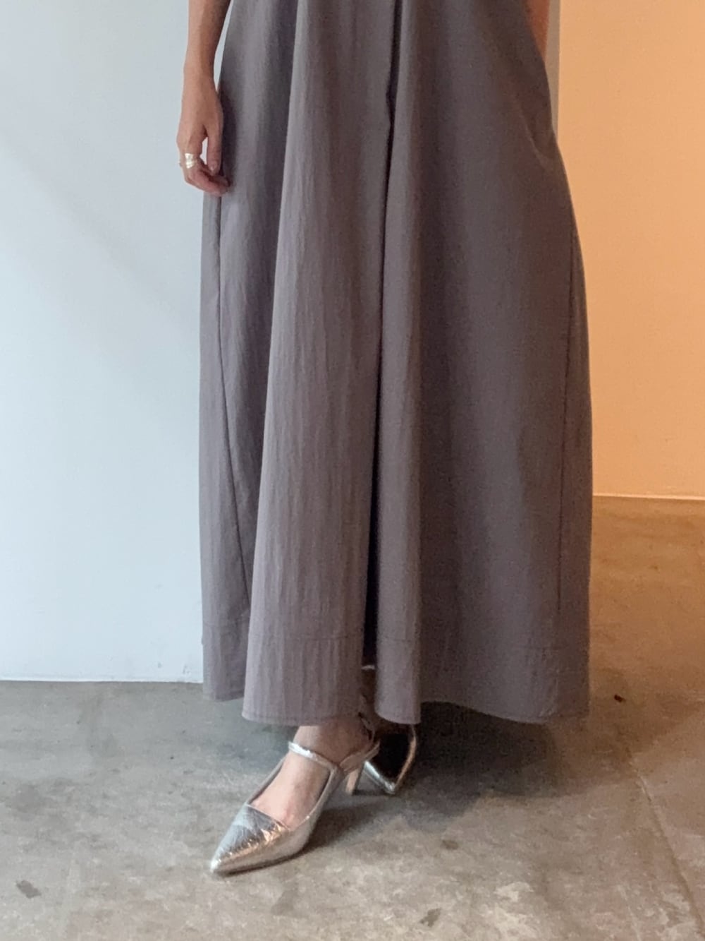 グレー系のワンピース、シルバー系のパンプス、レッド系のショルダーバッグを着用したレディースの夏コーディネートの7枚目の写真