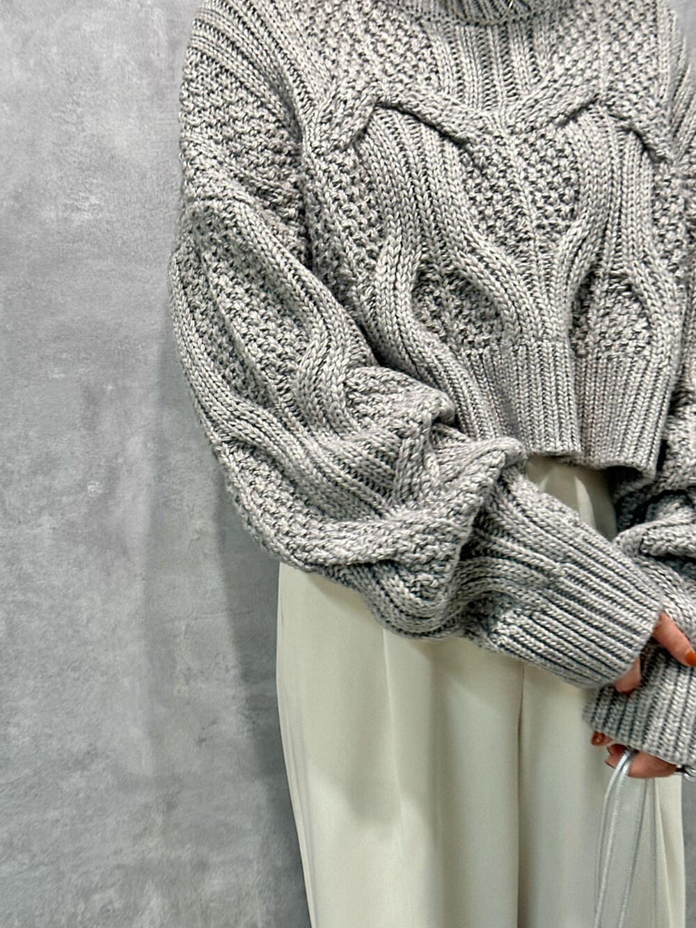 グレー系のニット/セーター、ホワイト系のその他パンツ、ブラック系のブーツを着用したレディースの秋コーディネートの5枚目の写真