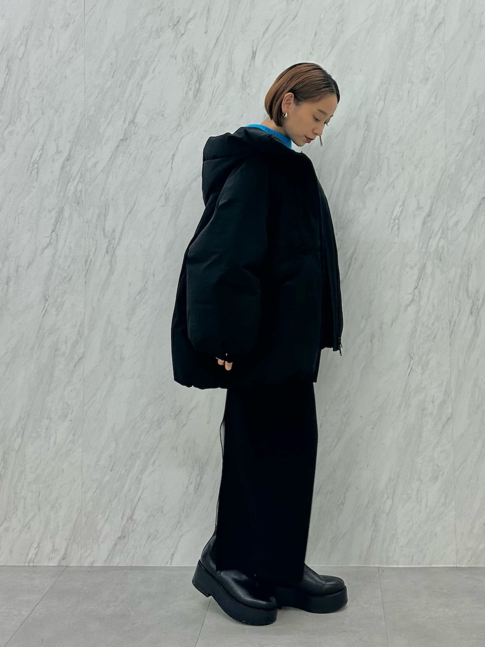 ブラック系のブーツ、ブラック系のスカート、ブラック系のダウンジャケット/コートを着用したレディースの秋コーディネートの3枚目の写真