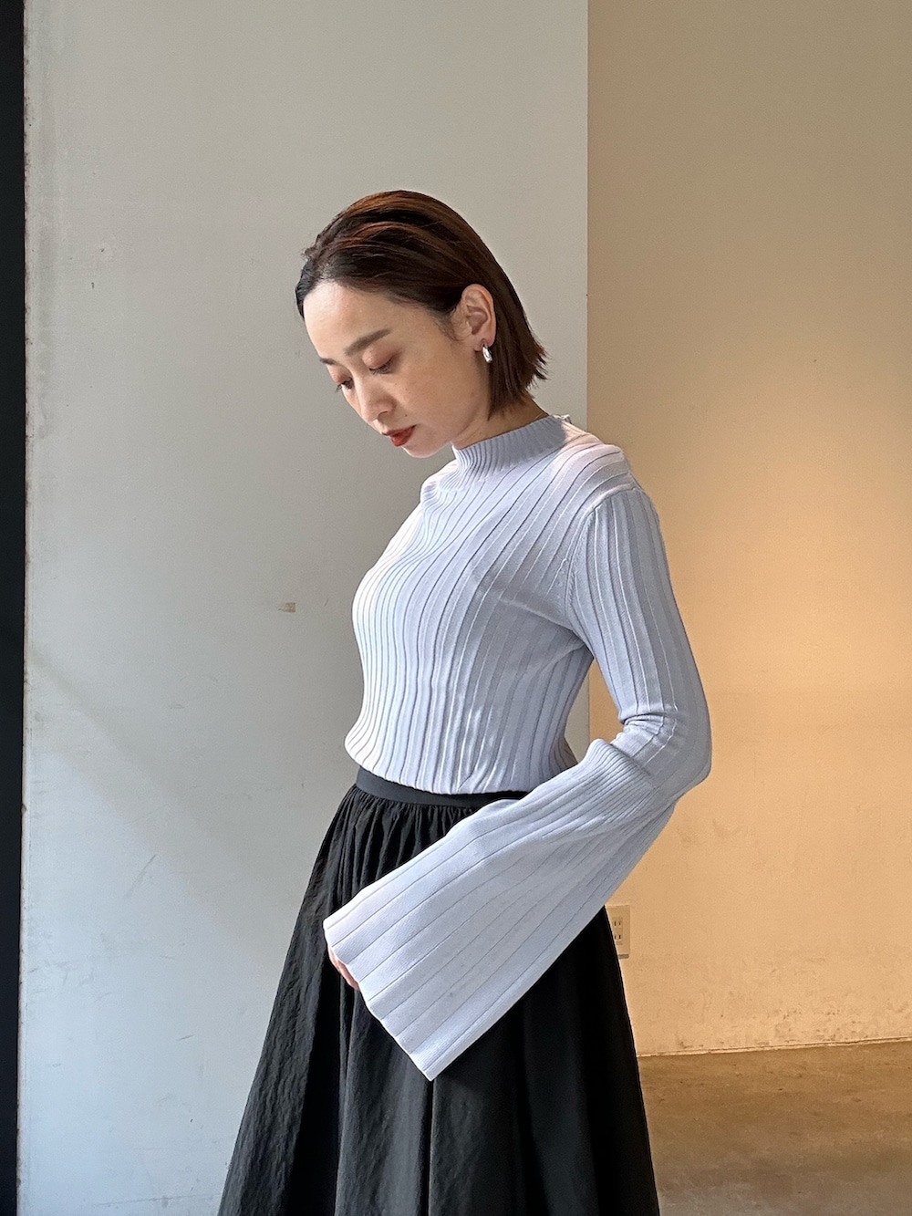 ブラック系のスカート、ブラック系のブーツ、パープル系のニット/セーターを着用したレディースの冬コーディネートの7枚目の写真