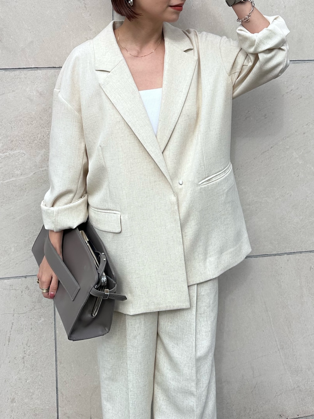 グレー系のハンドバッグ、ベージュ系のその他パンツ、シルバー系のサンダルを着用したレディースの春コーディネートの5枚目の写真