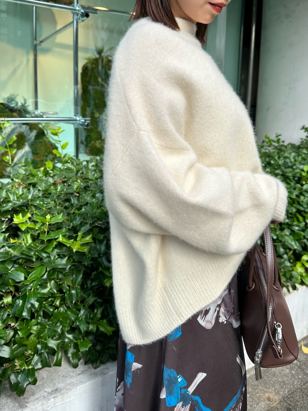 ホワイト系のニット/セーター、ブラウン系のスカート、ブラウン系のボストンバッグを着用したレディースの秋コーディネートの5枚目の写真