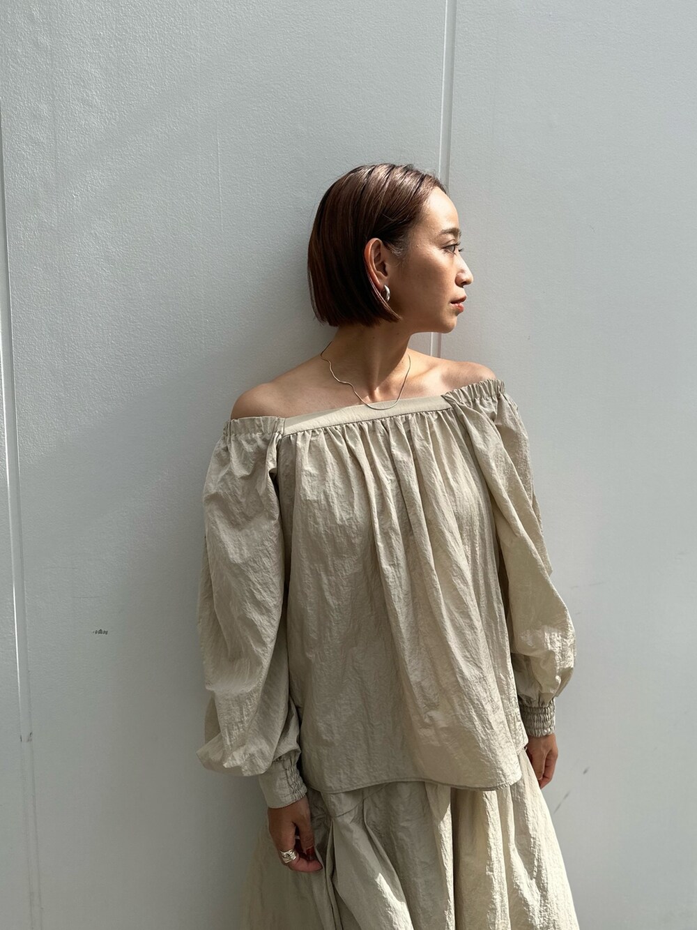 ベージュ系のブーツ、ベージュ系のスカート、ベージュ系のシャツ/ブラウスを着用したレディースの秋コーディネートの4枚目の写真