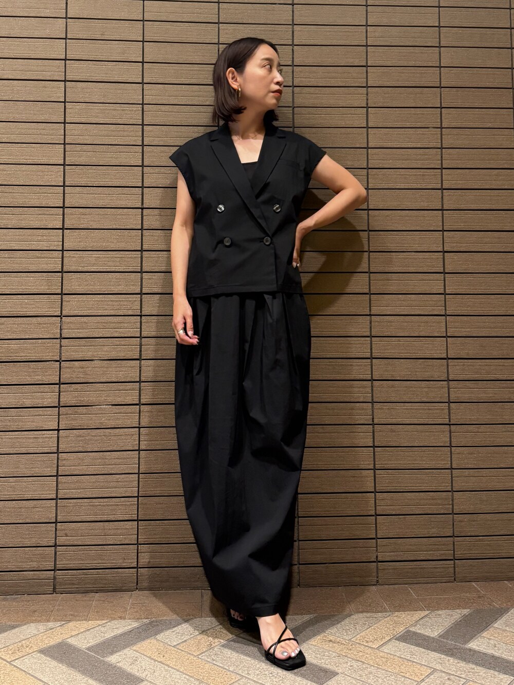 ブラック系のシャツ/ブラウス、ブラック系のスカート、ブラック系のサンダルを着用したレディースの夏コーディネートの5枚目の写真