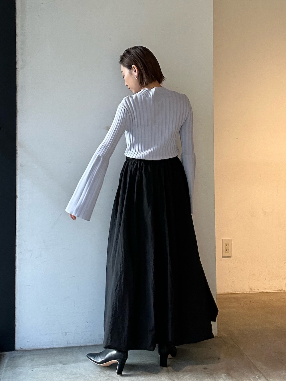 ブラック系のスカート、ブラック系のブーツ、パープル系のニット/セーターを着用したレディースの冬コーディネートの4枚目の写真