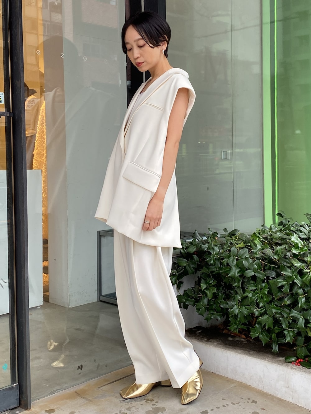 ホワイト系のテーラードジャケット、ゴールド系のパンプス、ホワイト系のその他パンツを着用したレディースの春コーディネートの2枚目の写真
