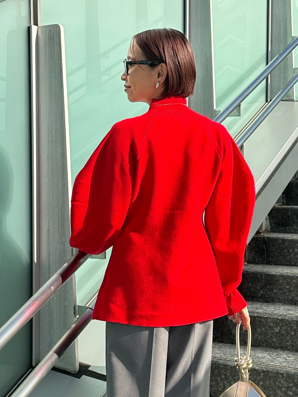 ブラック系のブーツ、グレー系のノーカラージャケット、レッド系のニット/セーターを着用したレディースの冬コーディネートの9枚目の写真