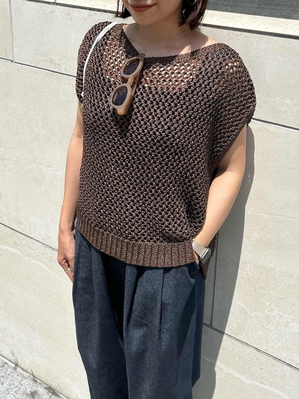 ブラウン系のニット/セーター、ブルー系のつなぎ/オールインワン、ゴールド系のサンダルを着用したレディースの春コーディネートの4枚目の写真