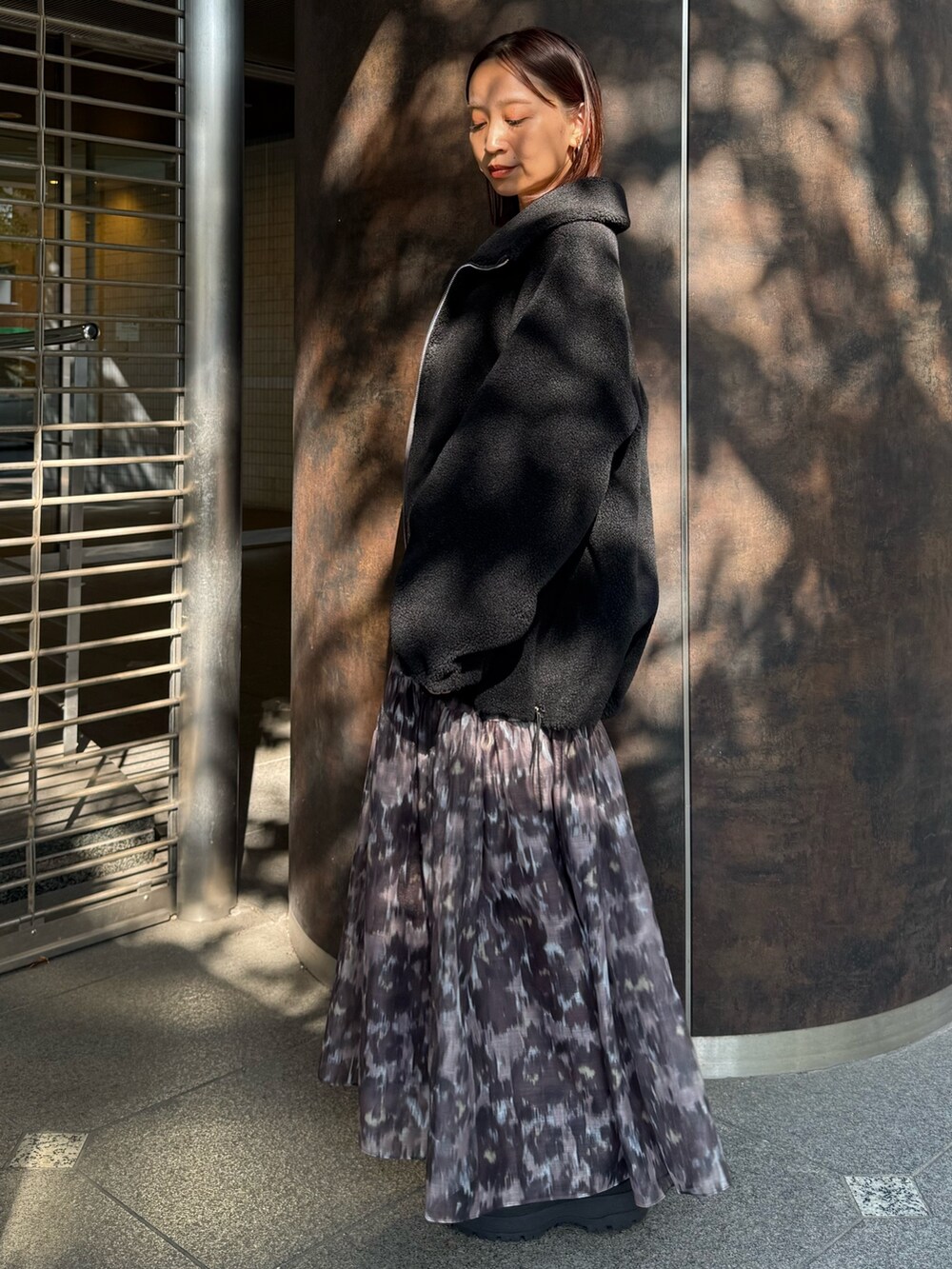 ブラウン系のワンピース、ブラック系のその他アウターを着用したレディースの秋コーディネートの2枚目の写真