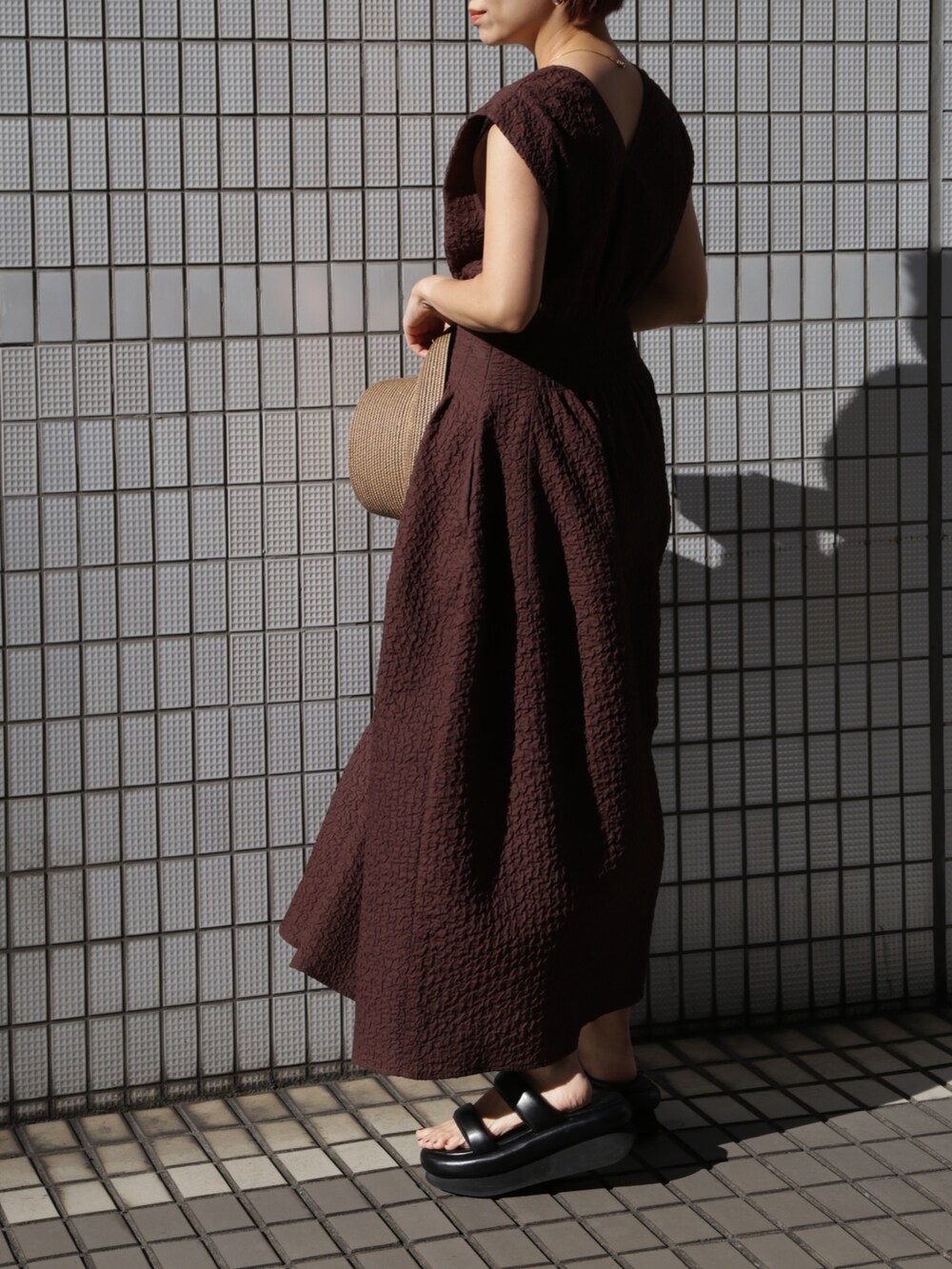 ブラウン系のワンピース、ブラック系のサンダルを着用したレディースの冬コーディネートの4枚目の写真