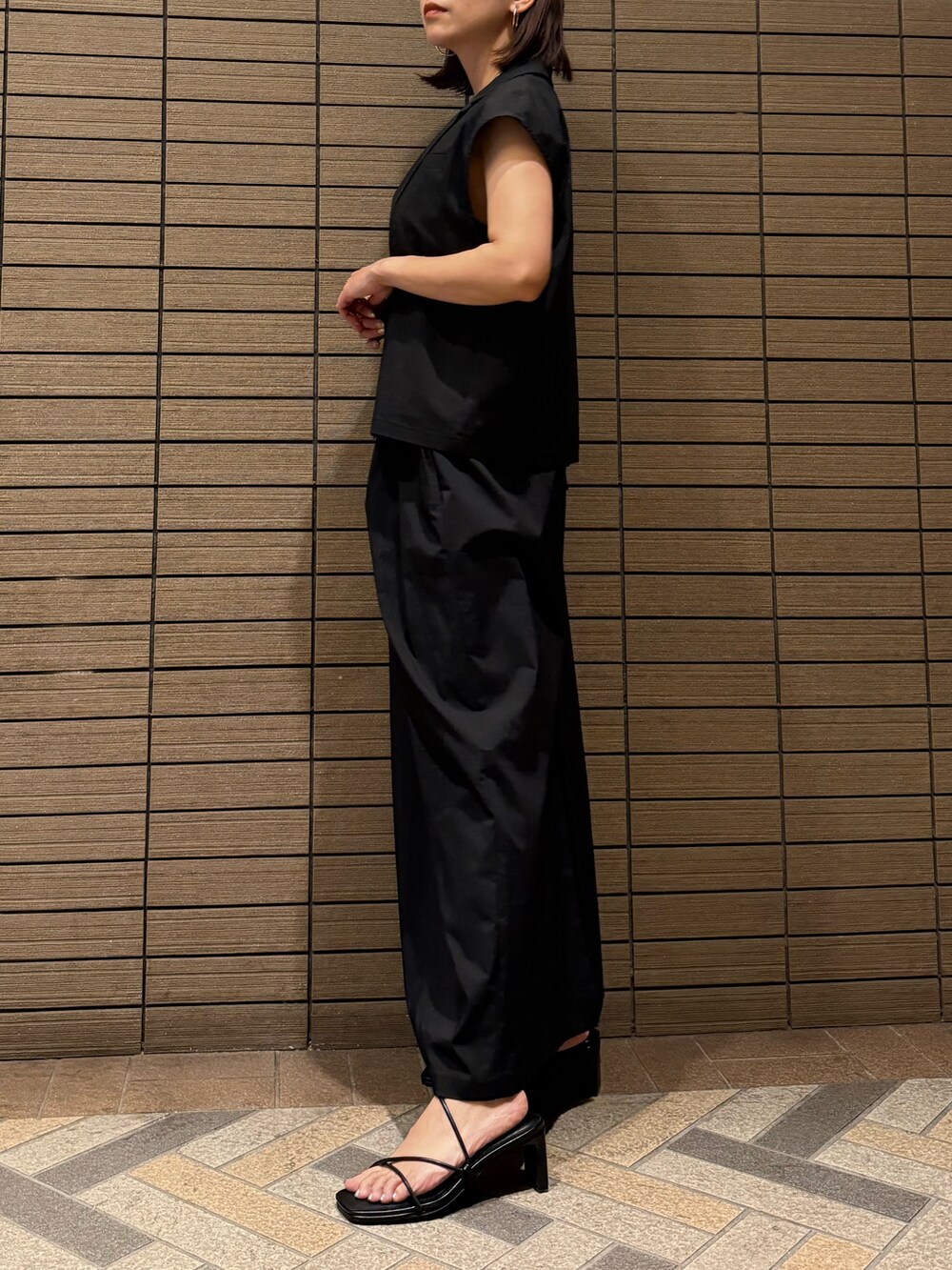 ブラック系のシャツ/ブラウス、ブラック系のスカート、ブラック系のサンダルを着用したレディースの夏コーディネートの3枚目の写真