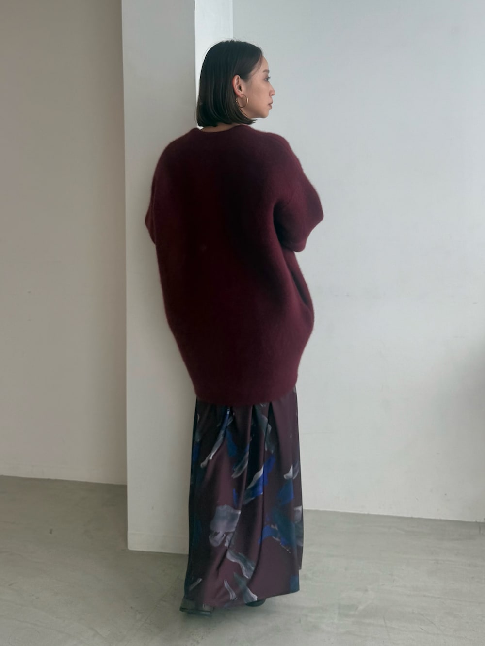 レッド系のスカート、レッド系のカーディガン/ボレロ、ブラック系のブーツを着用したレディースの夏コーディネートの4枚目の写真