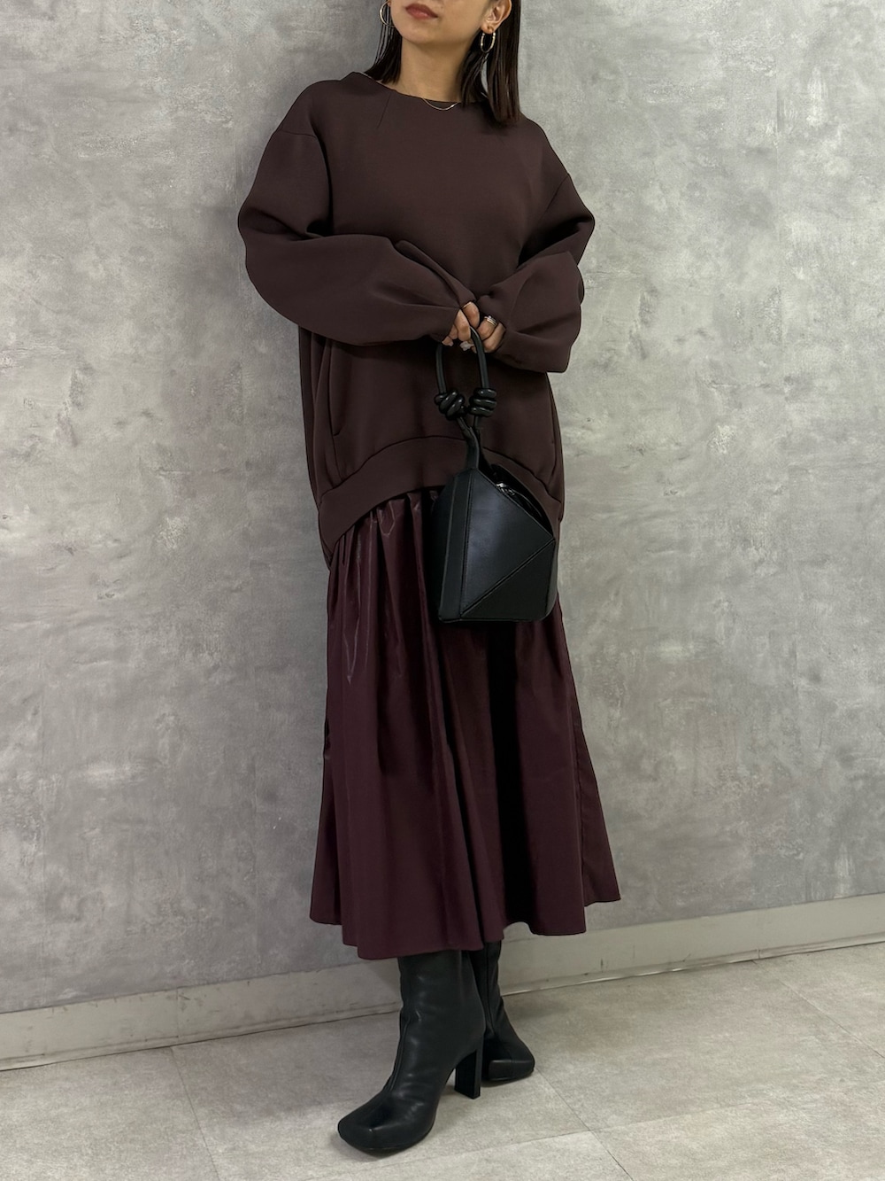 ブラウン系のワンピース、ブラック系のハンドバッグを着用したレディースの秋コーディネートの3枚目の写真
