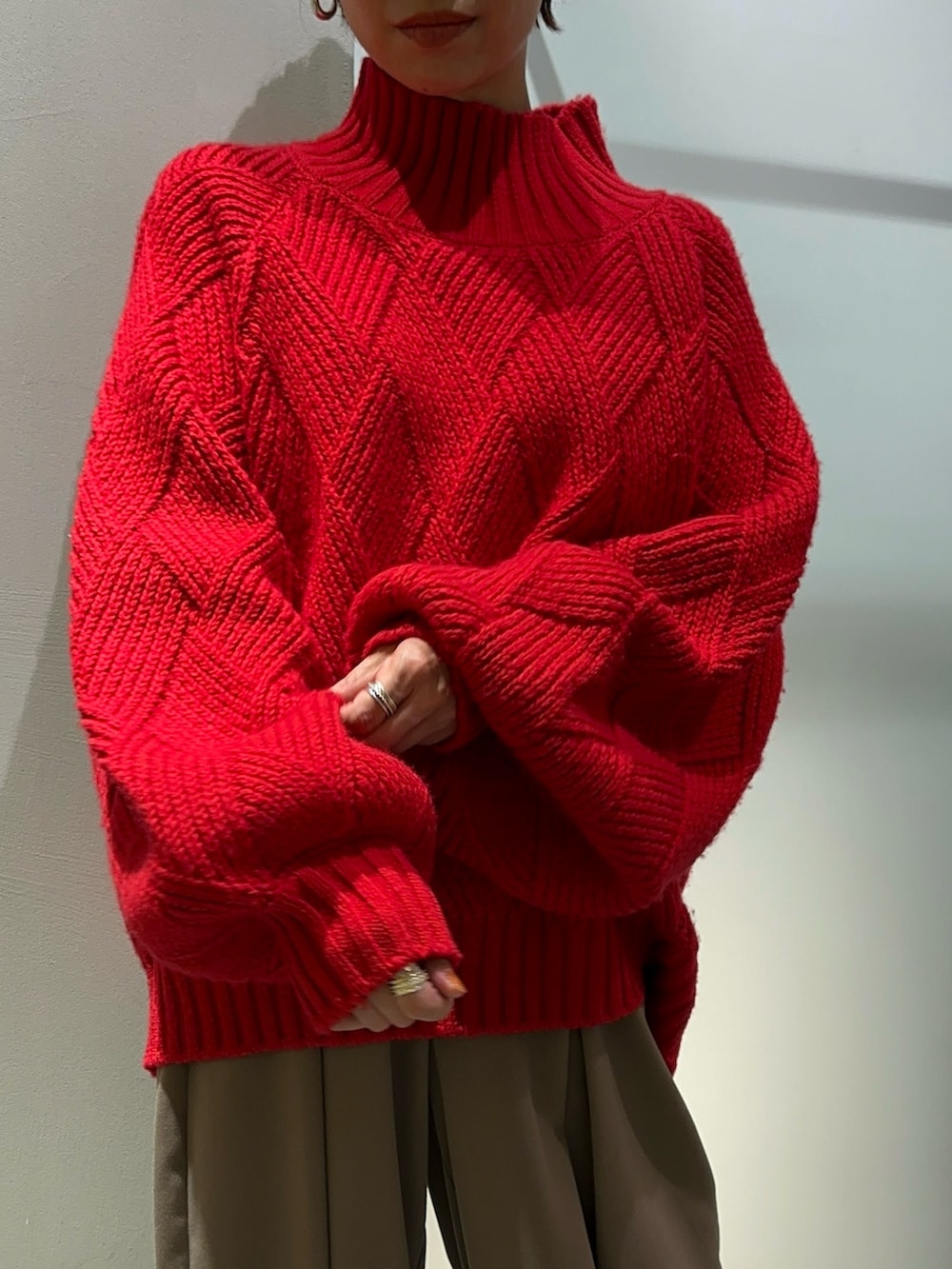 レッド系のニット/セーター、ブラウン系のその他パンツ、シルバー系のブーツを着用したレディースの秋コーディネートの7枚目の写真