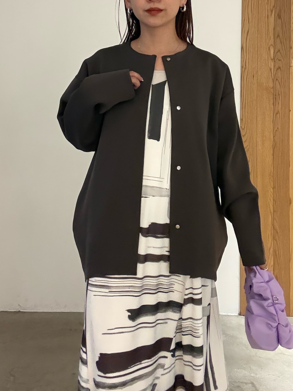 ホワイト系のワンピース、ブラック系のパンプス、パープル系のハンドバッグを着用したレディースの冬コーディネートの4枚目の写真