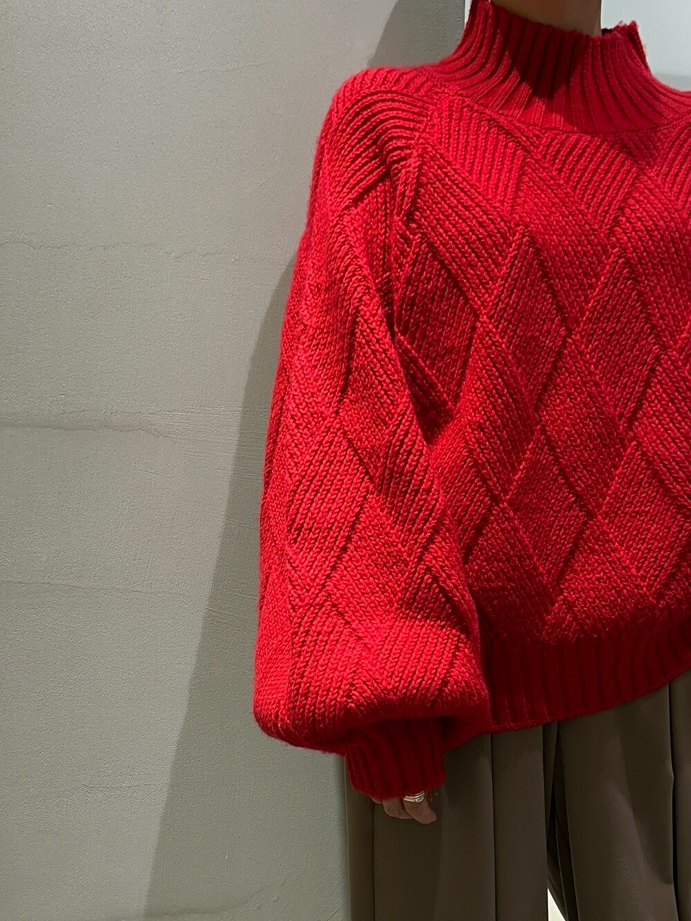 レッド系のニット/セーター、ブラウン系のその他パンツ、シルバー系のブーツを着用したレディースの秋コーディネートの6枚目の写真