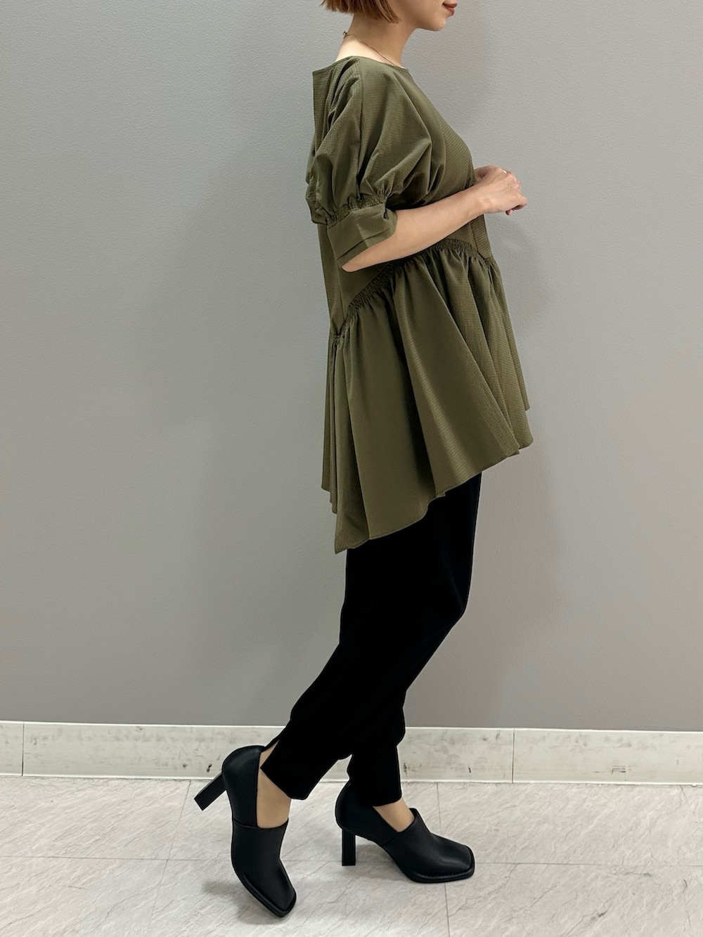 グリーン系のシャツ/ブラウス、ブラック系のスラックス、ブラック系のパンプスを着用したレディースの夏コーディネートの4枚目の写真