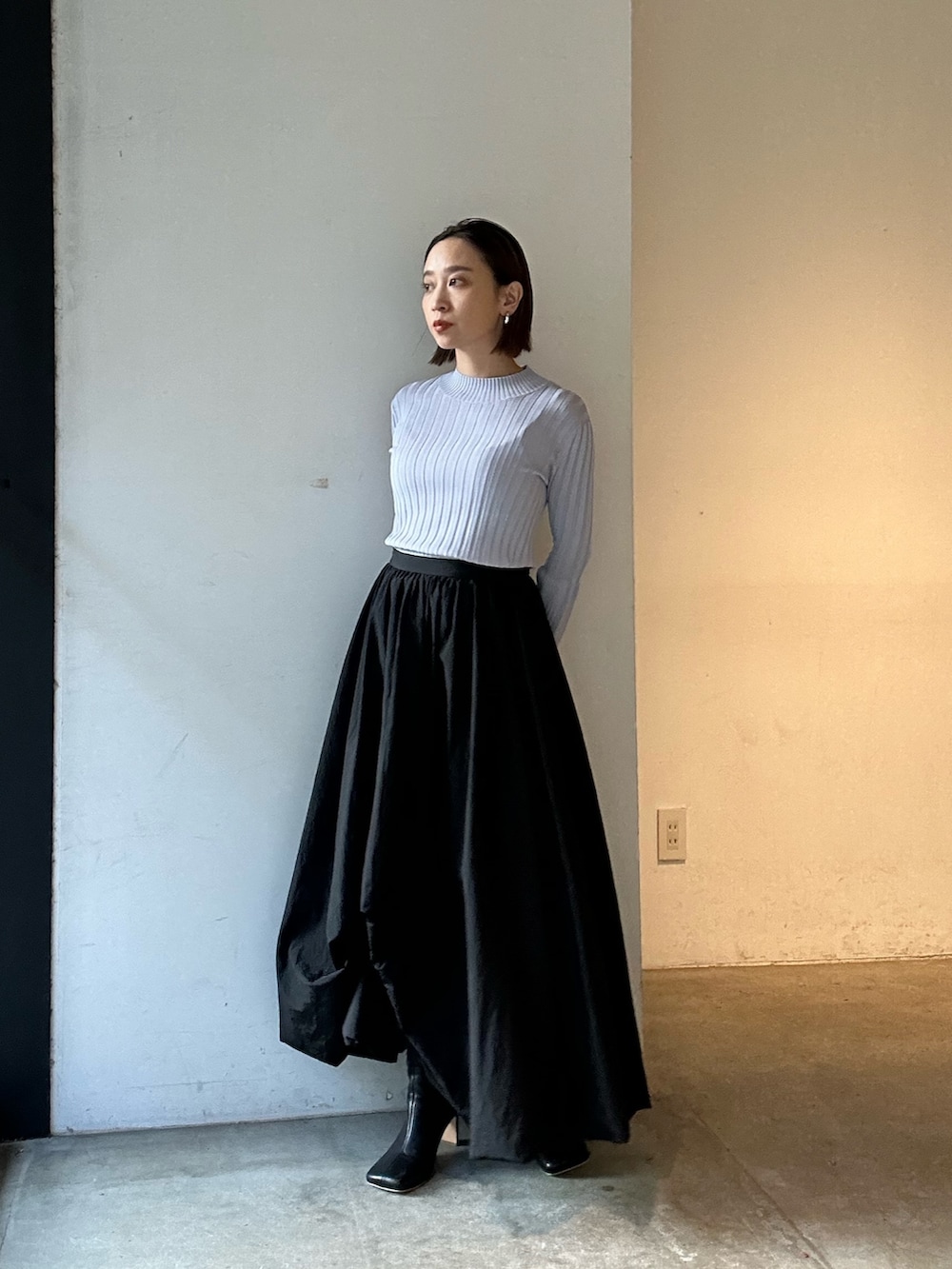 ブラック系のスカート、ブラック系のブーツ、パープル系のニット/セーターを着用したレディースの冬コーディネートの6枚目の写真