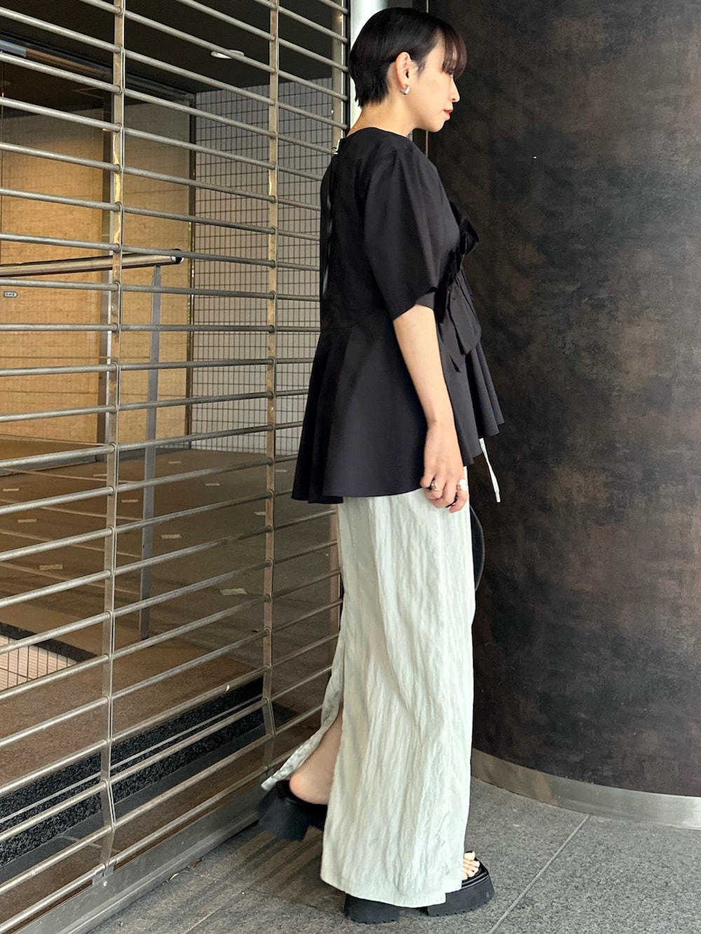 ブラック系のシャツ/ブラウス、グリーン系のスカート、ブラック系のサンダルを着用したレディースの夏コーディネートの3枚目の写真