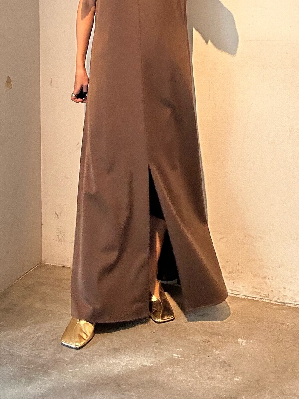 ブラウン系のワンピース、ゴールド系のパンプスを着用したレディースの春コーディネートの6枚目の写真