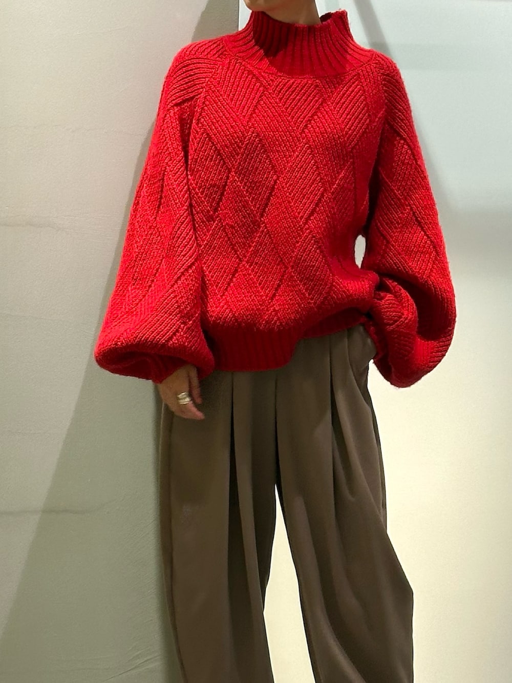 レッド系のニット/セーター、ブラウン系のその他パンツ、シルバー系のブーツを着用したレディースの秋コーディネートの3枚目の写真