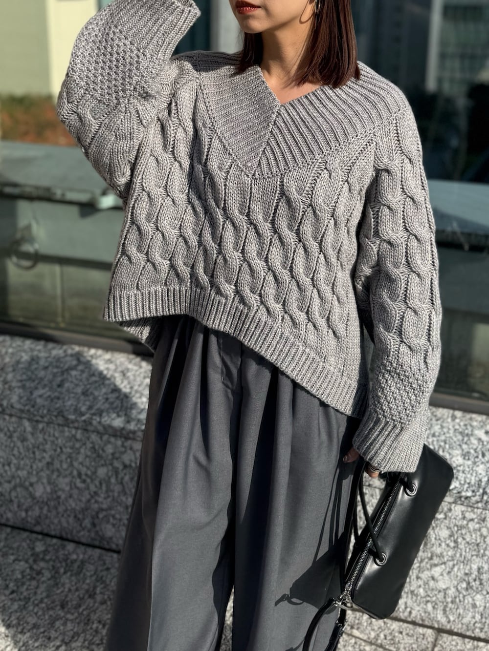 グレー系のその他パンツ、グレー系のニット/セーター、ブラック系のローファーを着用したレディースの冬コーディネートの7枚目の写真