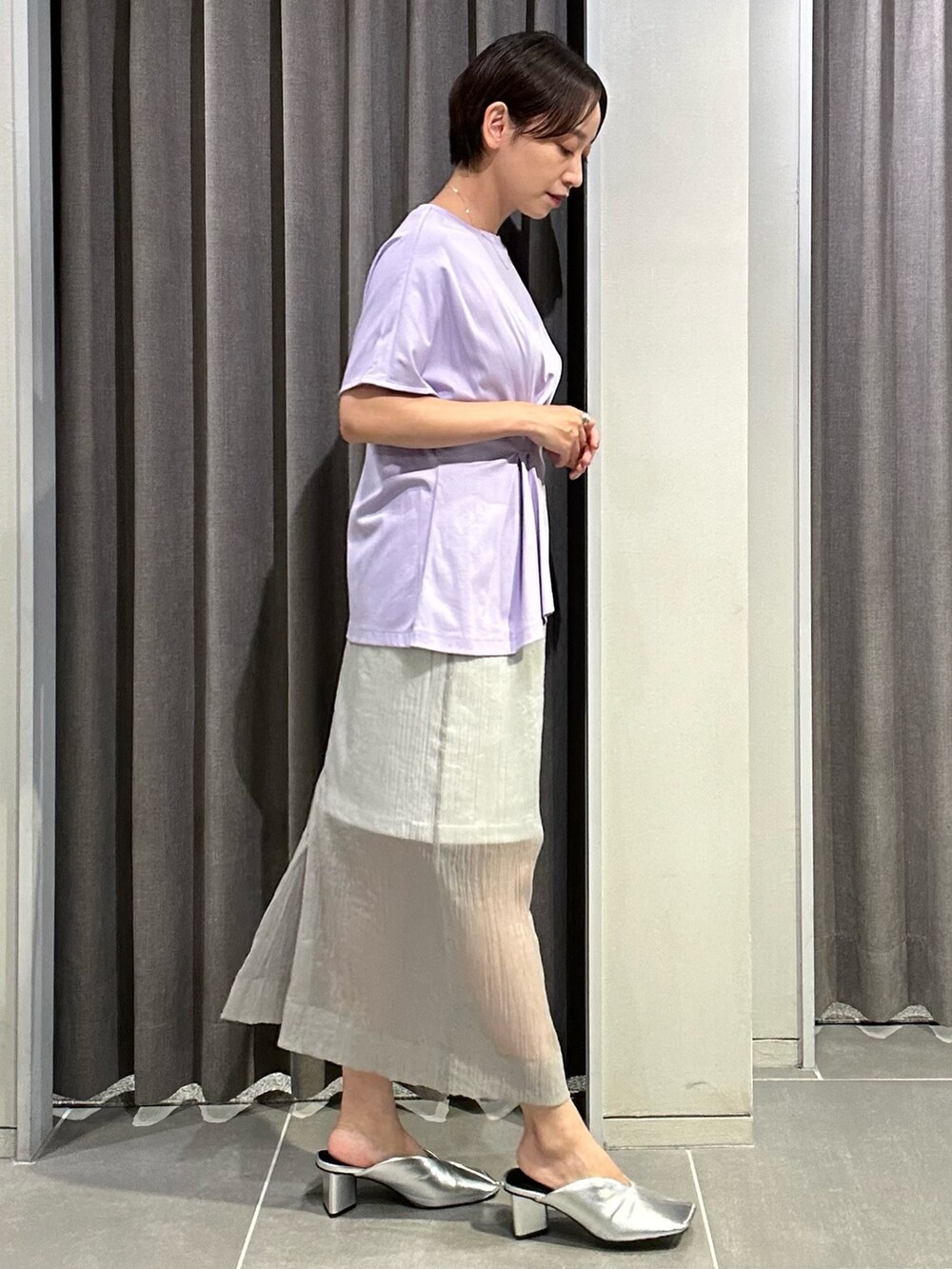 パープル系のTシャツ/カットソー、グレー系のスカート、シルバー系のパンプスを着用したレディースの夏コーディネートの6枚目の写真