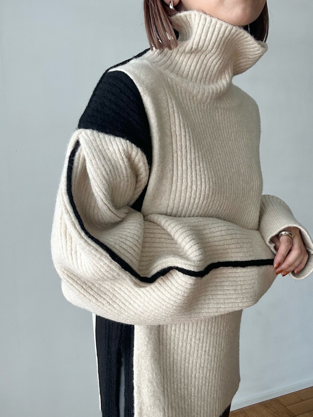 ホワイト系のニット/セーター、グレー系のその他パンツ、ブラック系のブーツを着用したレディースの秋コーディネートの9枚目の写真