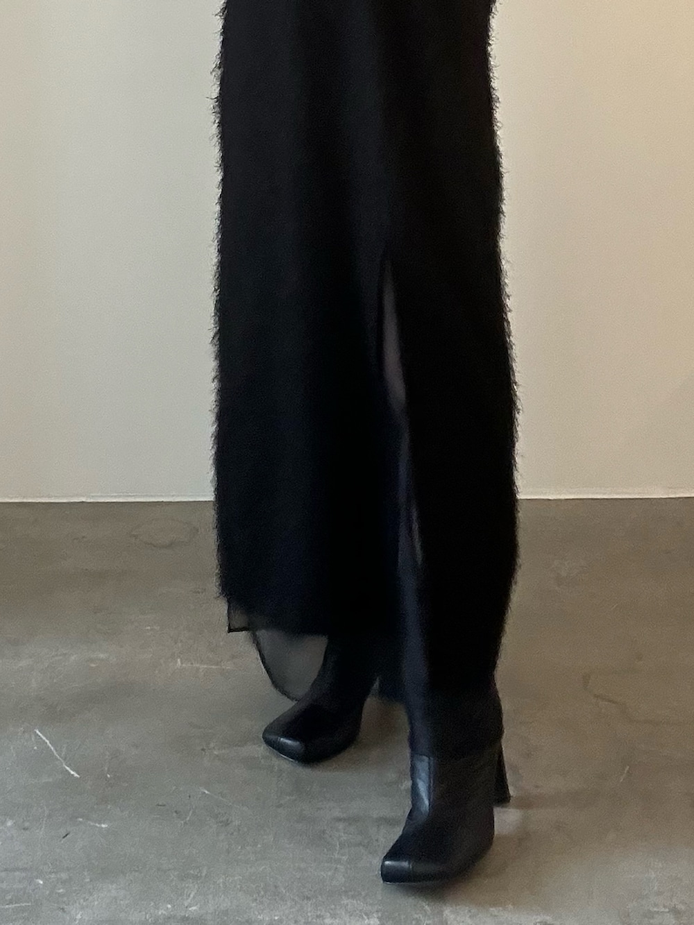 ブラック系のワンピース、シルバー系のハンドバッグ、ブラック系のブーツを着用したレディースの秋コーディネートの6枚目の写真