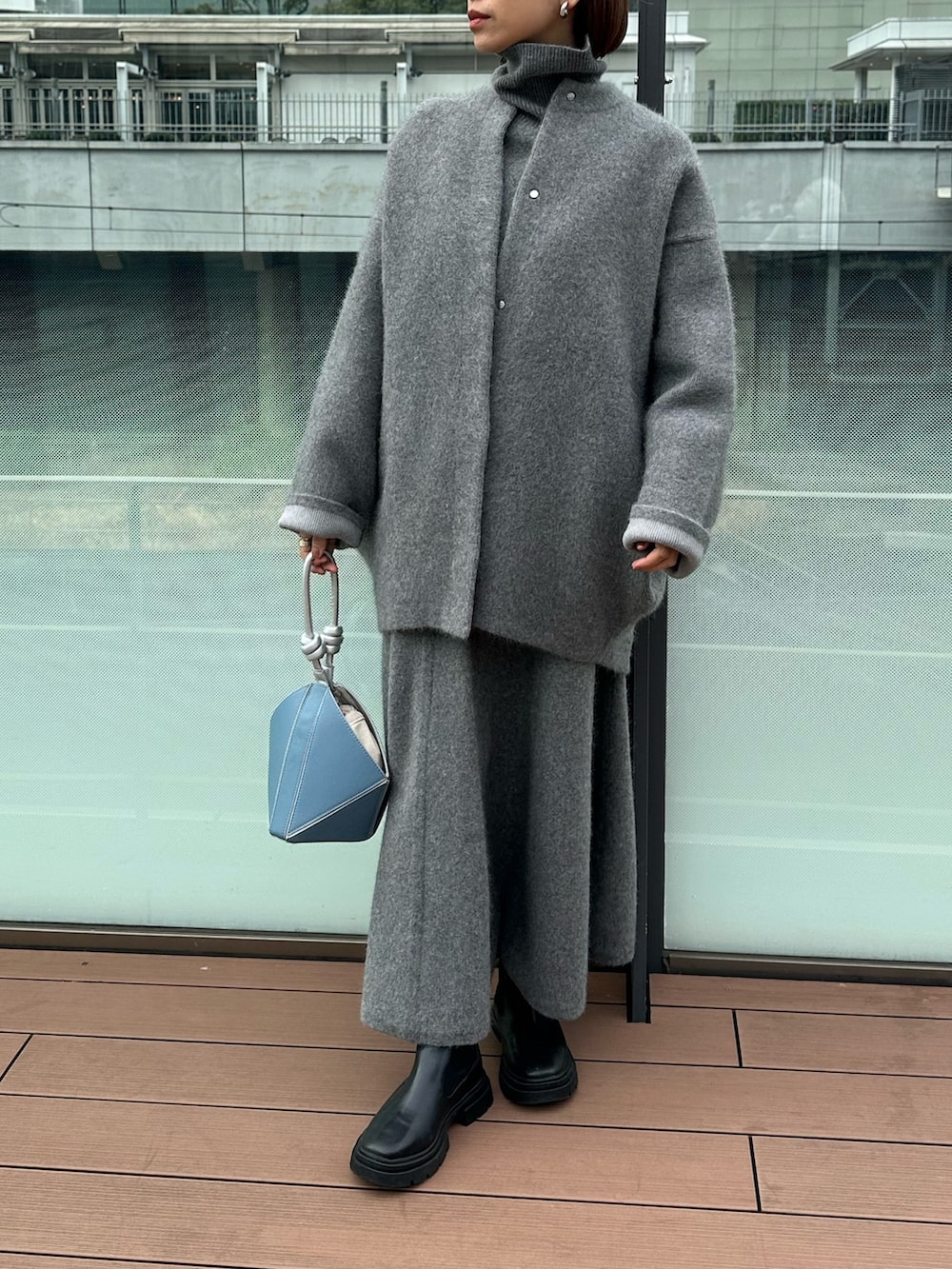 グレー系のスカート、グレー系のノーカラージャケット、グレー系のニット/セーターを着用したレディースの冬コーディネートの3枚目の写真