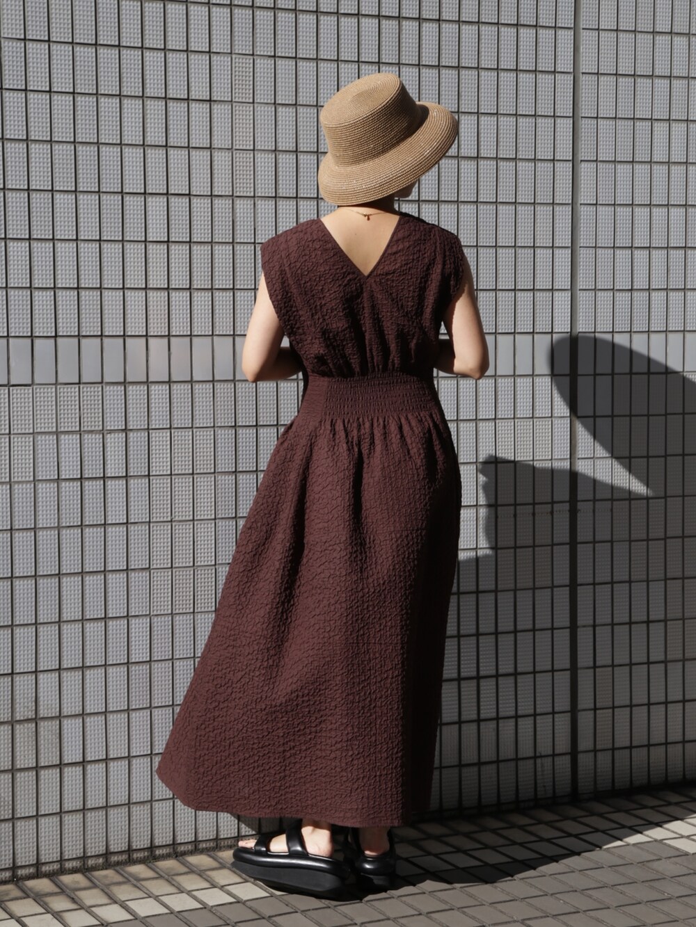 ブラウン系のワンピース、ブラック系のサンダルを着用したレディースの冬コーディネートの2枚目の写真