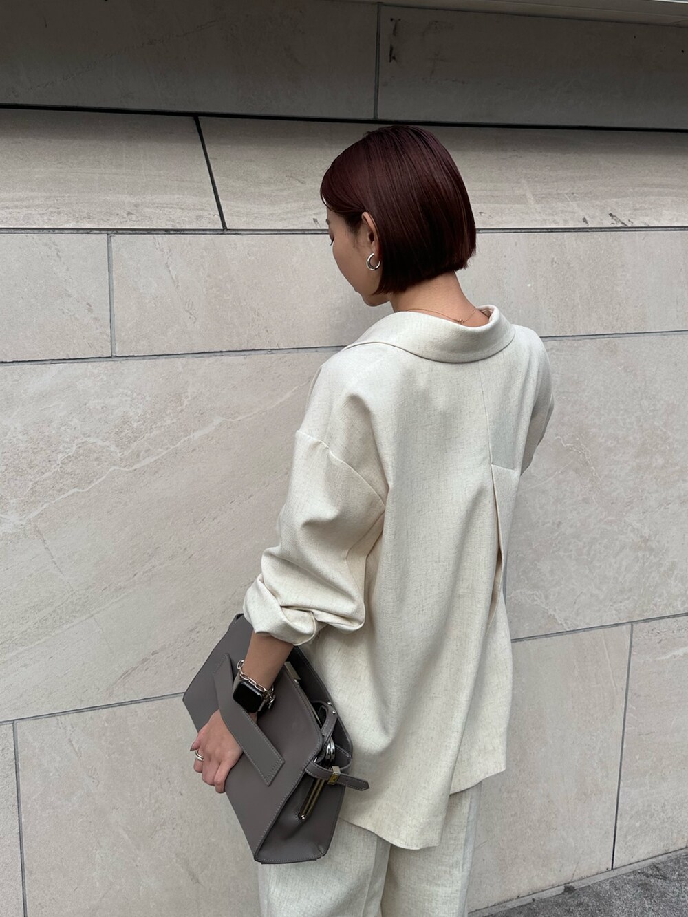 グレー系のハンドバッグ、ベージュ系のその他パンツ、シルバー系のサンダルを着用したレディースの春コーディネートの7枚目の写真