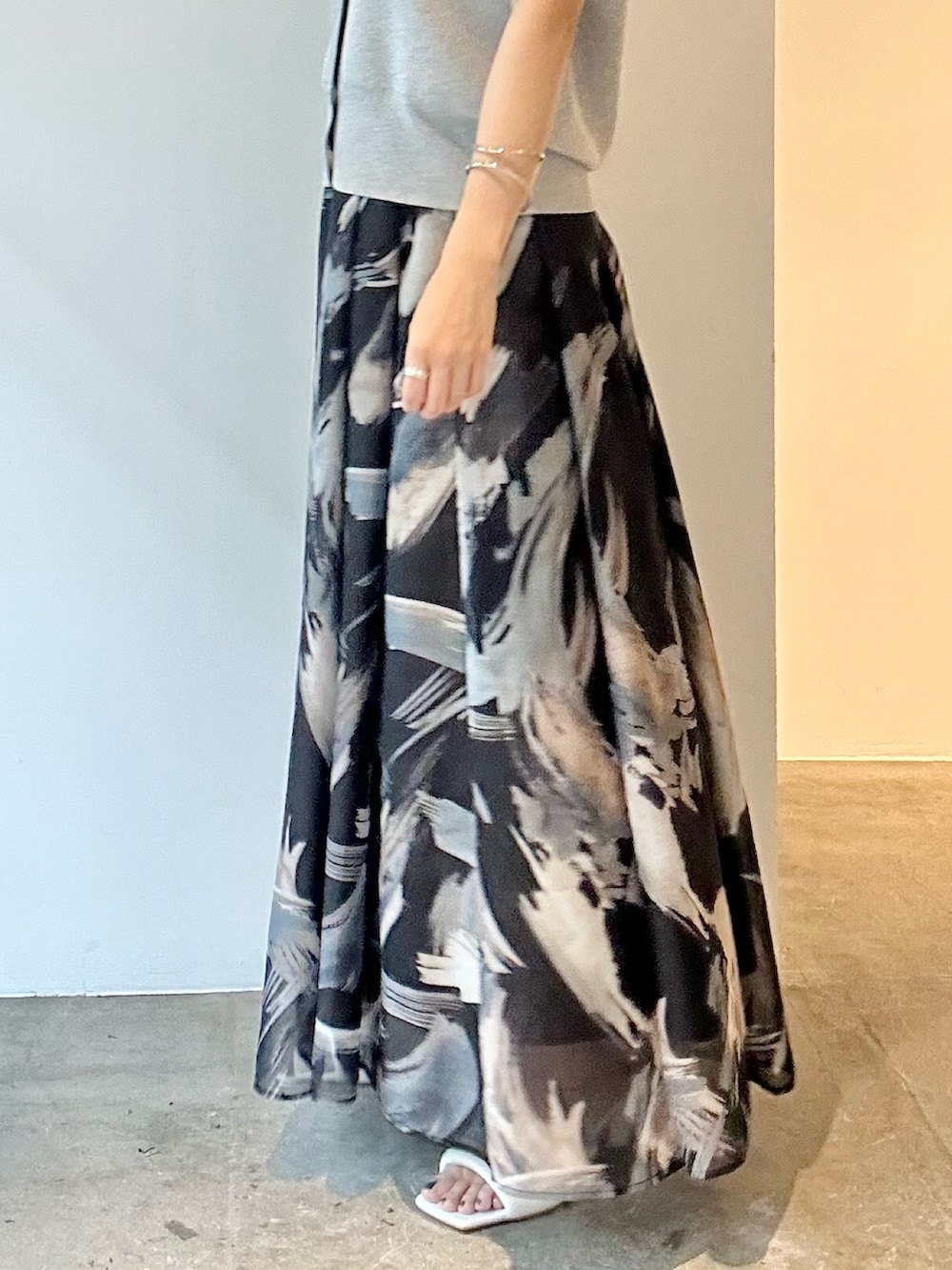 ブラック系のスカート、ホワイト系のサンダル、グレー系のニット/セーターを着用したレディースの春コーディネートの8枚目の写真