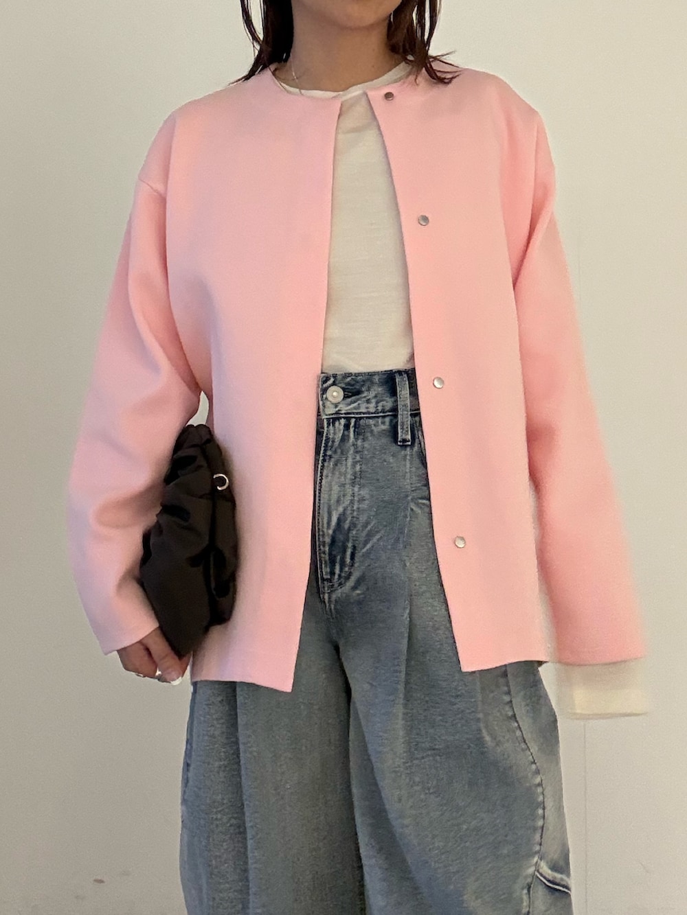 ブルー系のデニムパンツ、ブラック系のパンプス、ピンク系のカーディガン/ボレロを着用したレディースの冬コーディネートの4枚目の写真