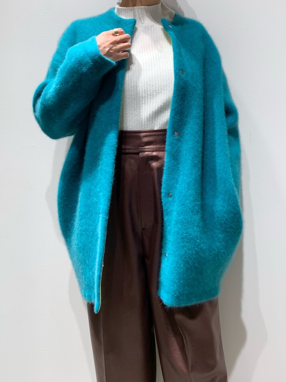 グリーン系のカーディガン/ボレロ、ブラウン系のその他パンツ、ブラック系のブーツを着用したレディースの秋コーディネートの2枚目の写真