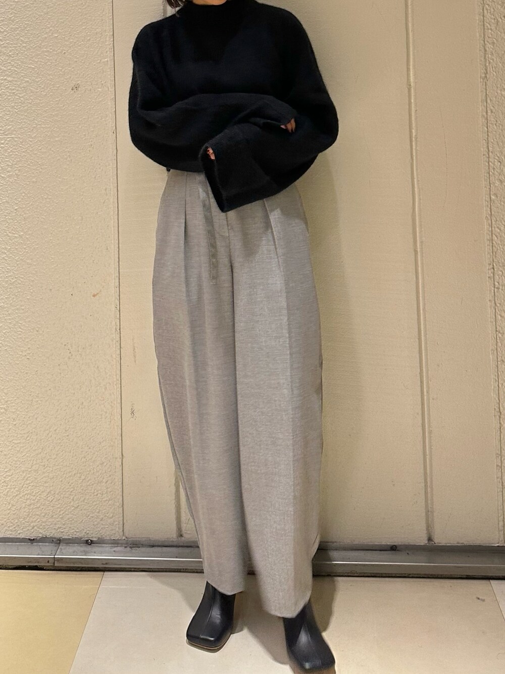 ブラック系のニット/セーター、グレー系のその他パンツ、ブラック系のブーツを着用したレディースの冬コーディネートの4枚目の写真