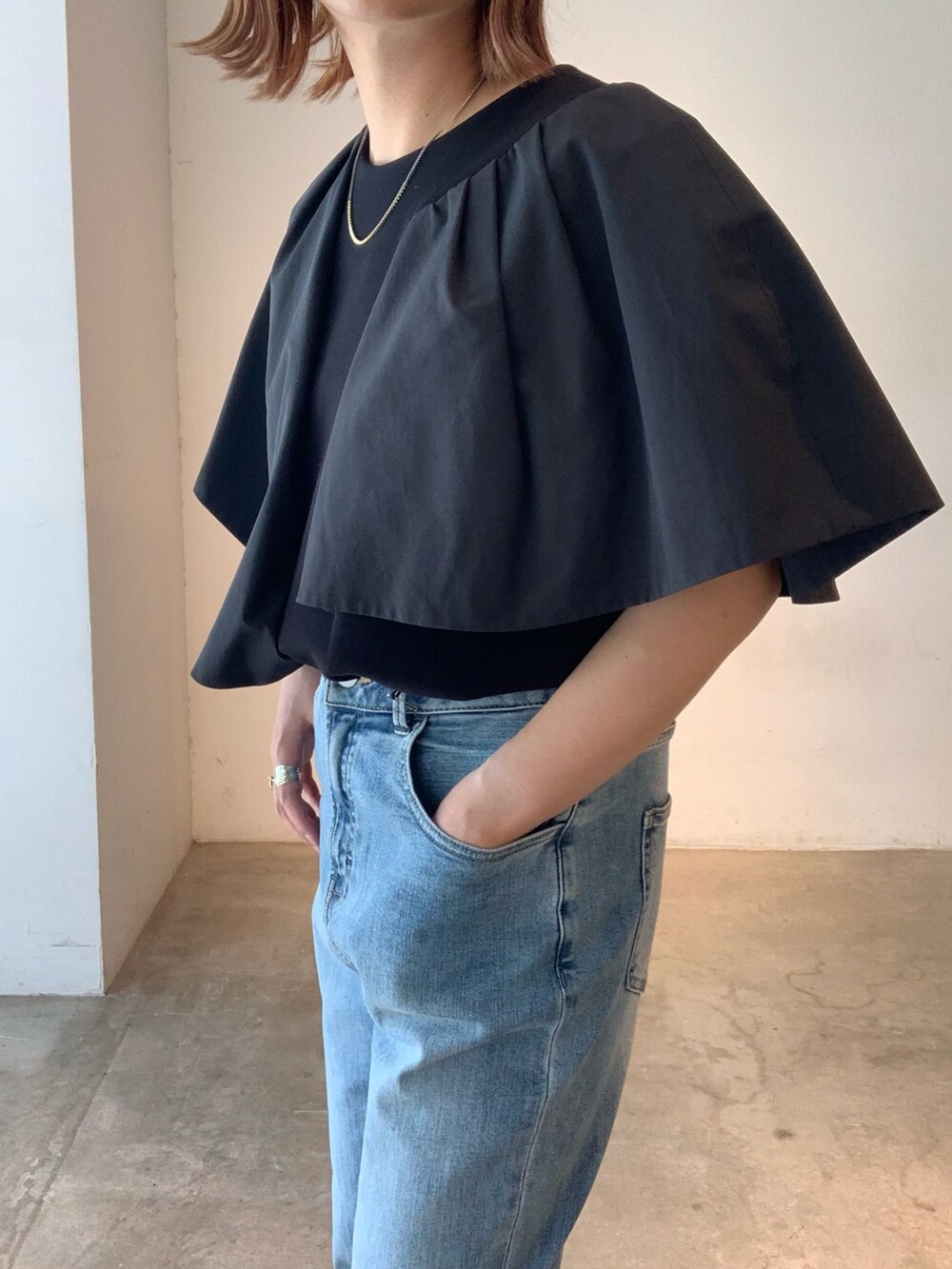 ブラック系のTシャツ/カットソー、ブルー系のデニムパンツ、ブラック系のサンダルを着用したレディースの春コーディネートの8枚目の写真