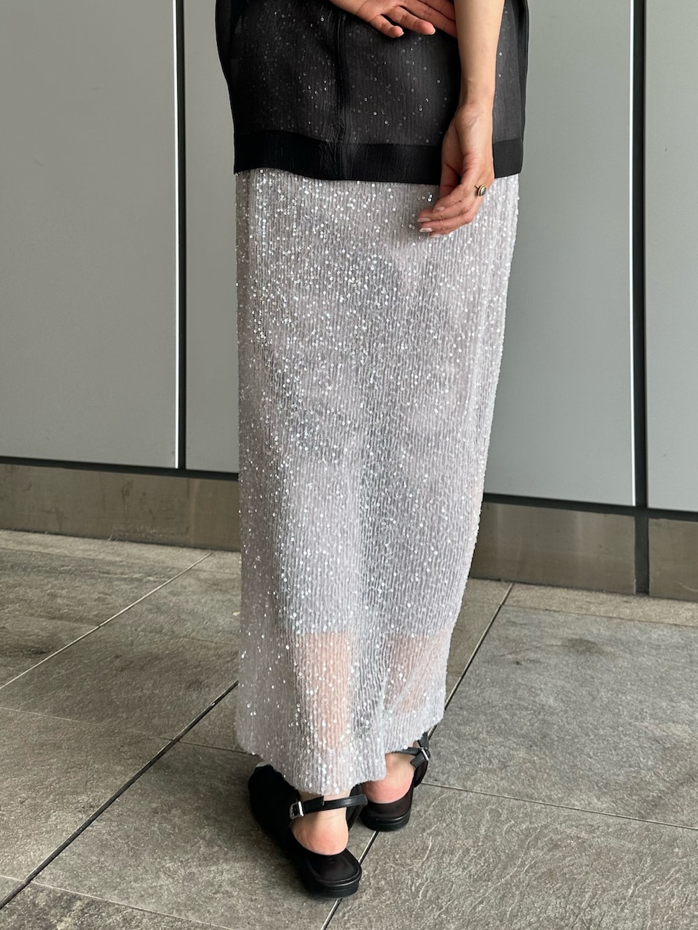 ブラック系のシャツ/ブラウス、シルバー系のスカートを着用したレディースの夏コーディネートの9枚目の写真