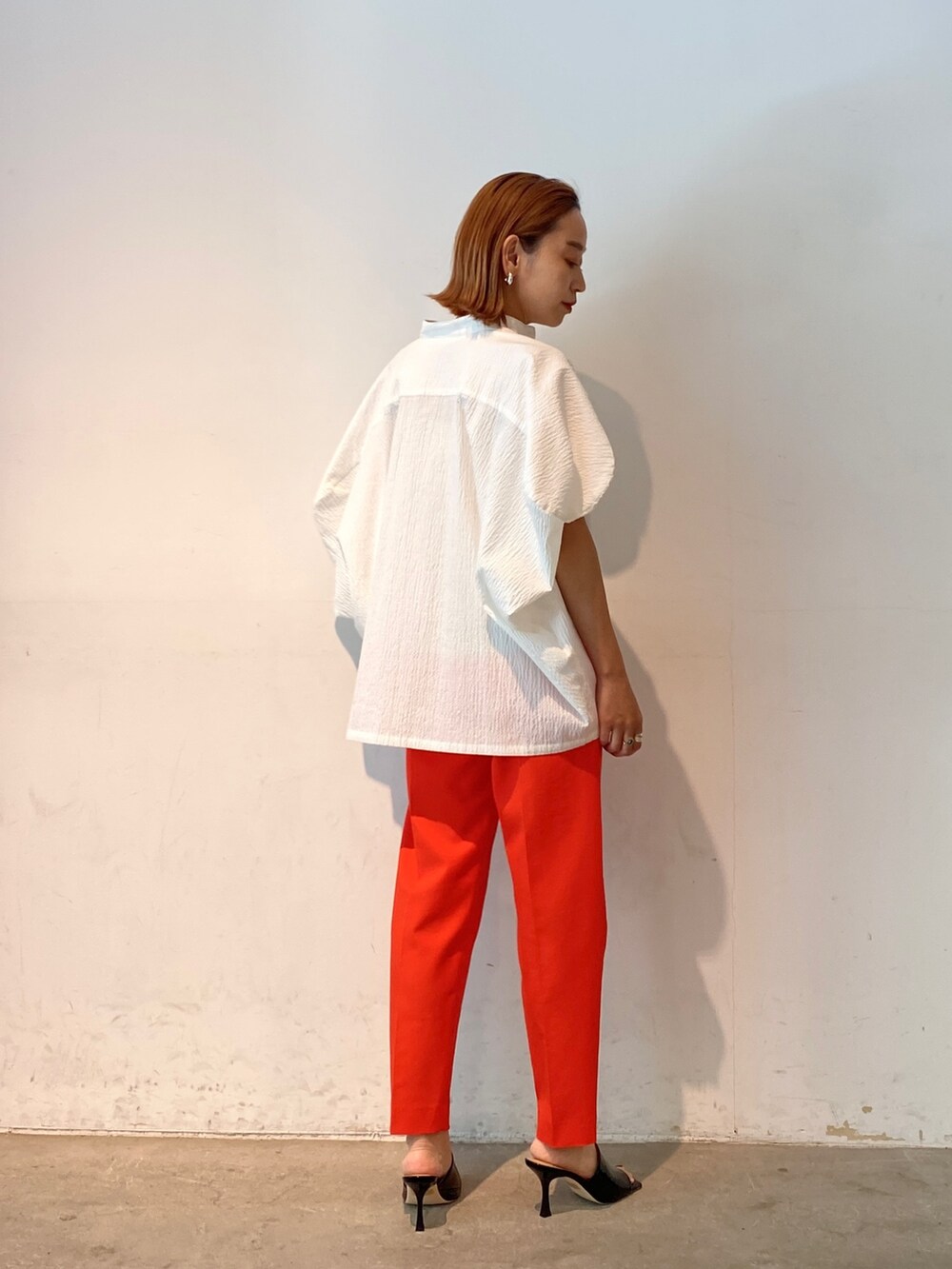 レッド系のその他パンツ、ホワイト系のシャツ/ブラウス、ブラック系のサンダルを着用したレディースの春コーディネートの5枚目の写真