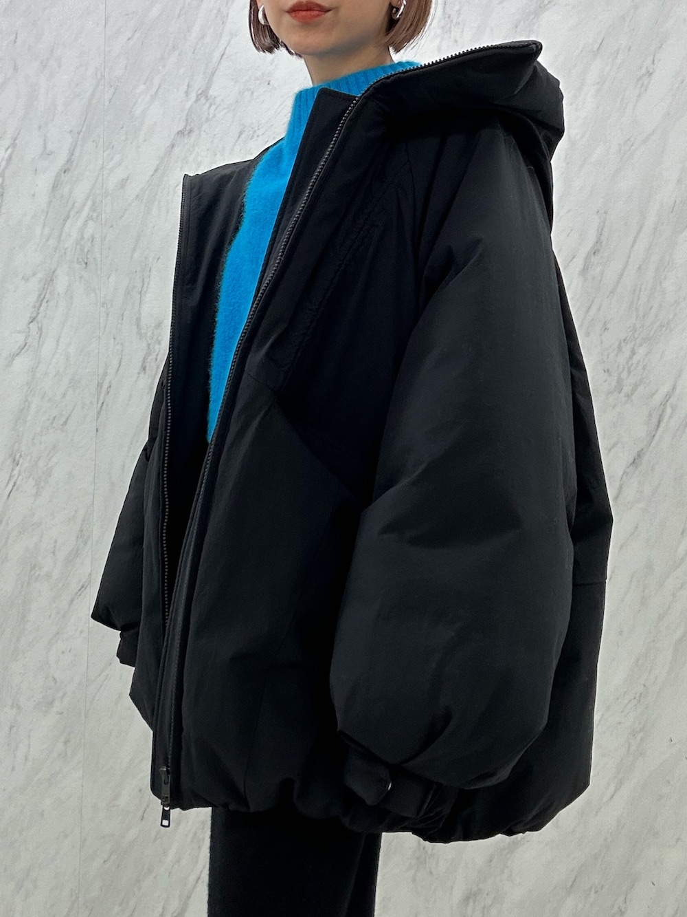 ブラック系のブーツ、ブラック系のスカート、ブラック系のダウンジャケット/コートを着用したレディースの秋コーディネートの6枚目の写真