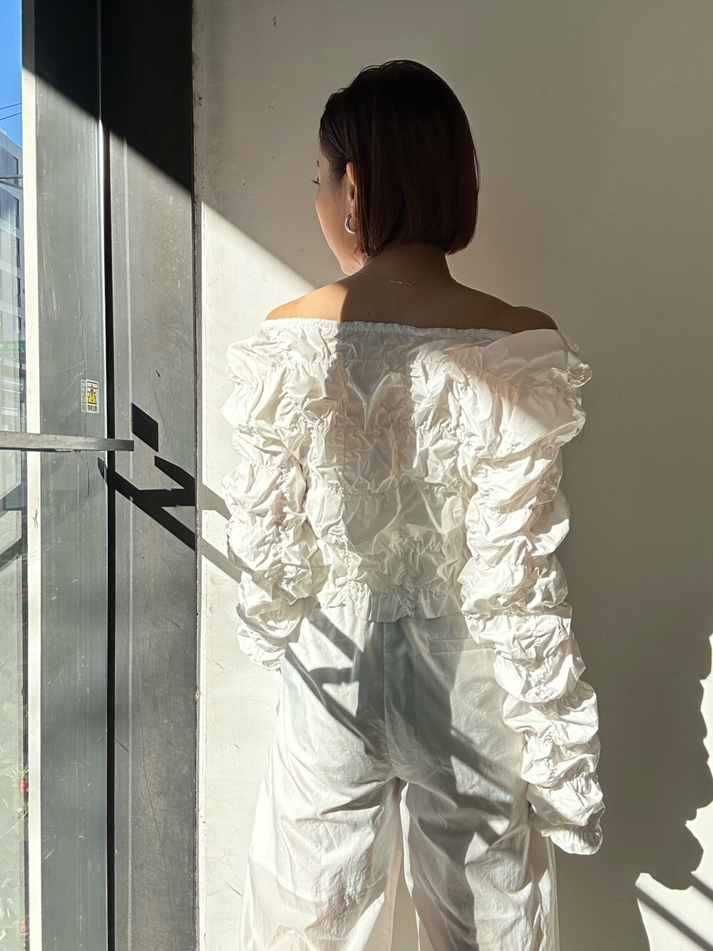ホワイト系のその他パンツ、シルバー系のパンプス、ホワイト系のカーディガン/ボレロを着用したレディースの冬コーディネートの10枚目の写真