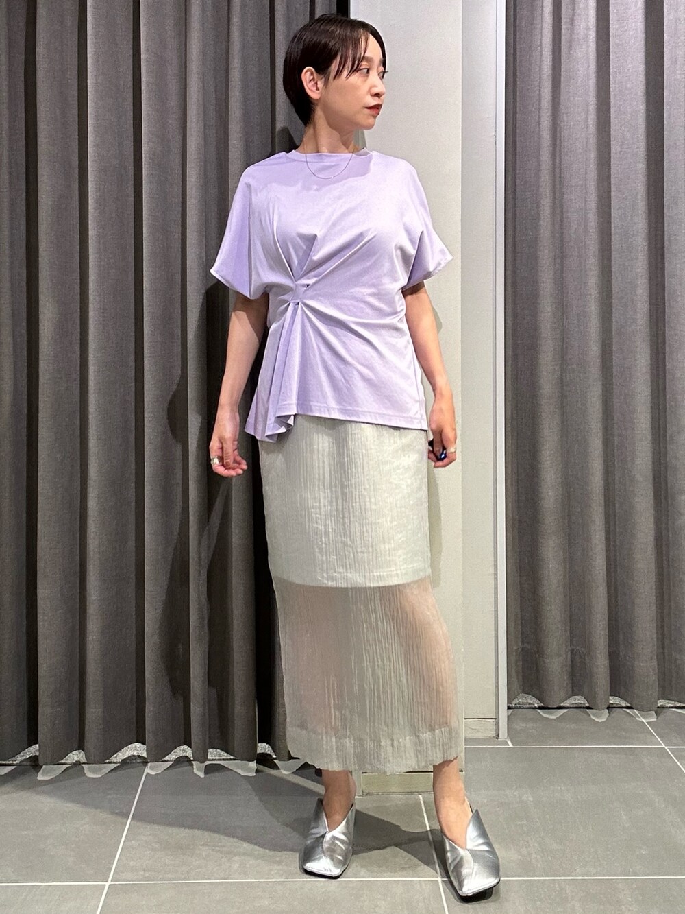パープル系のTシャツ/カットソー、グレー系のスカート、シルバー系のパンプスを着用したレディースの夏コーディネートの3枚目の写真