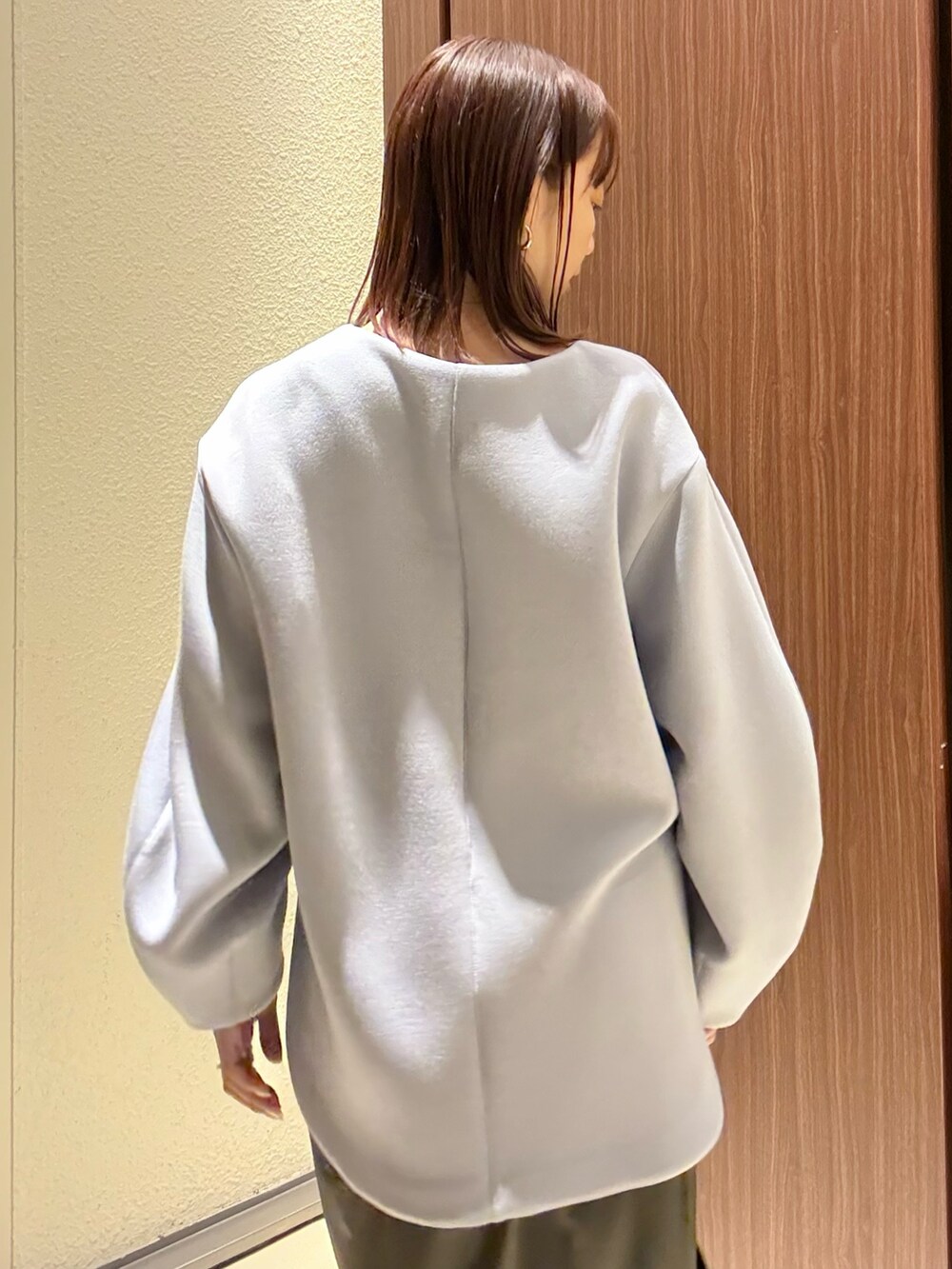 ブルー系のTシャツ/カットソー、ブラウン系のスカート、ブラウン系のブーツを着用したレディースの冬コーディネートの9枚目の写真