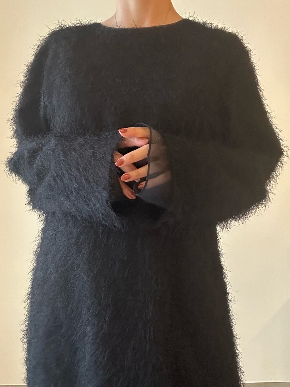 ブラック系のワンピース、シルバー系のハンドバッグ、ブラック系のブーツを着用したレディースの秋コーディネートの4枚目の写真